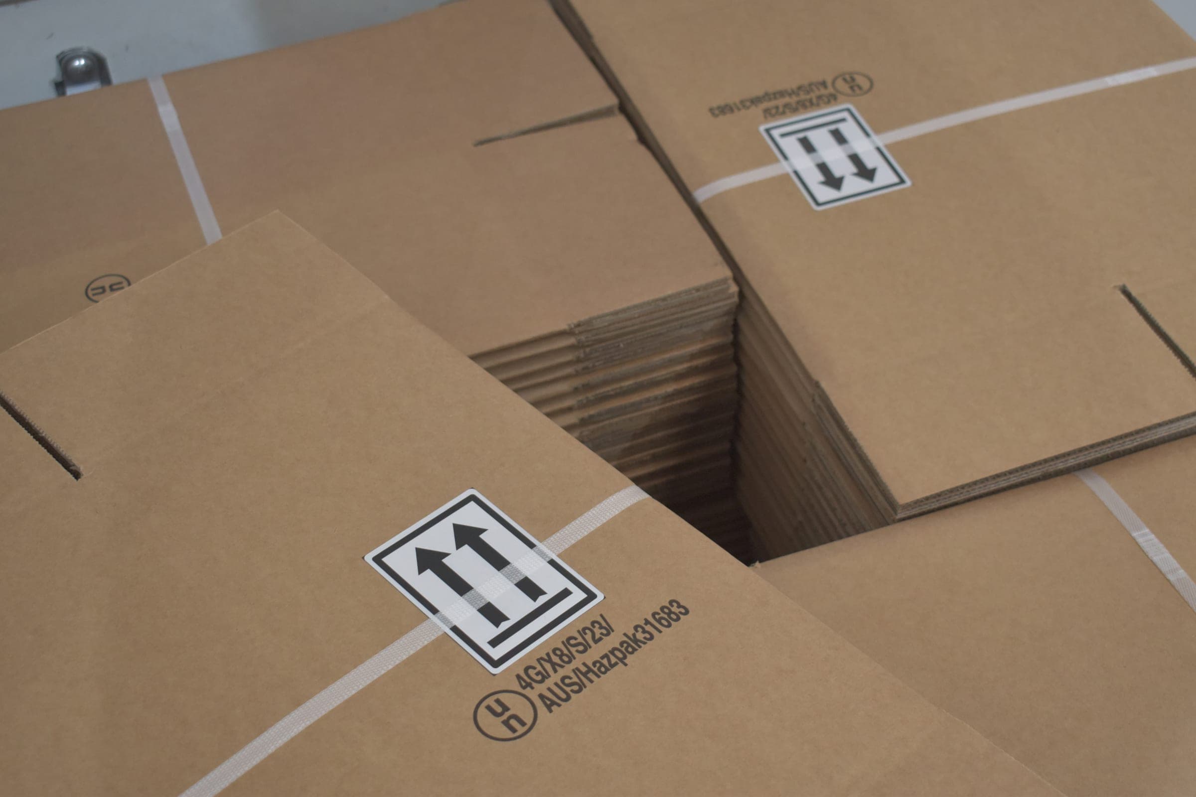 Fibreboard boxes marked with the UN 4G packaging code, orientation arrows and packaging group symbol on the closed carton