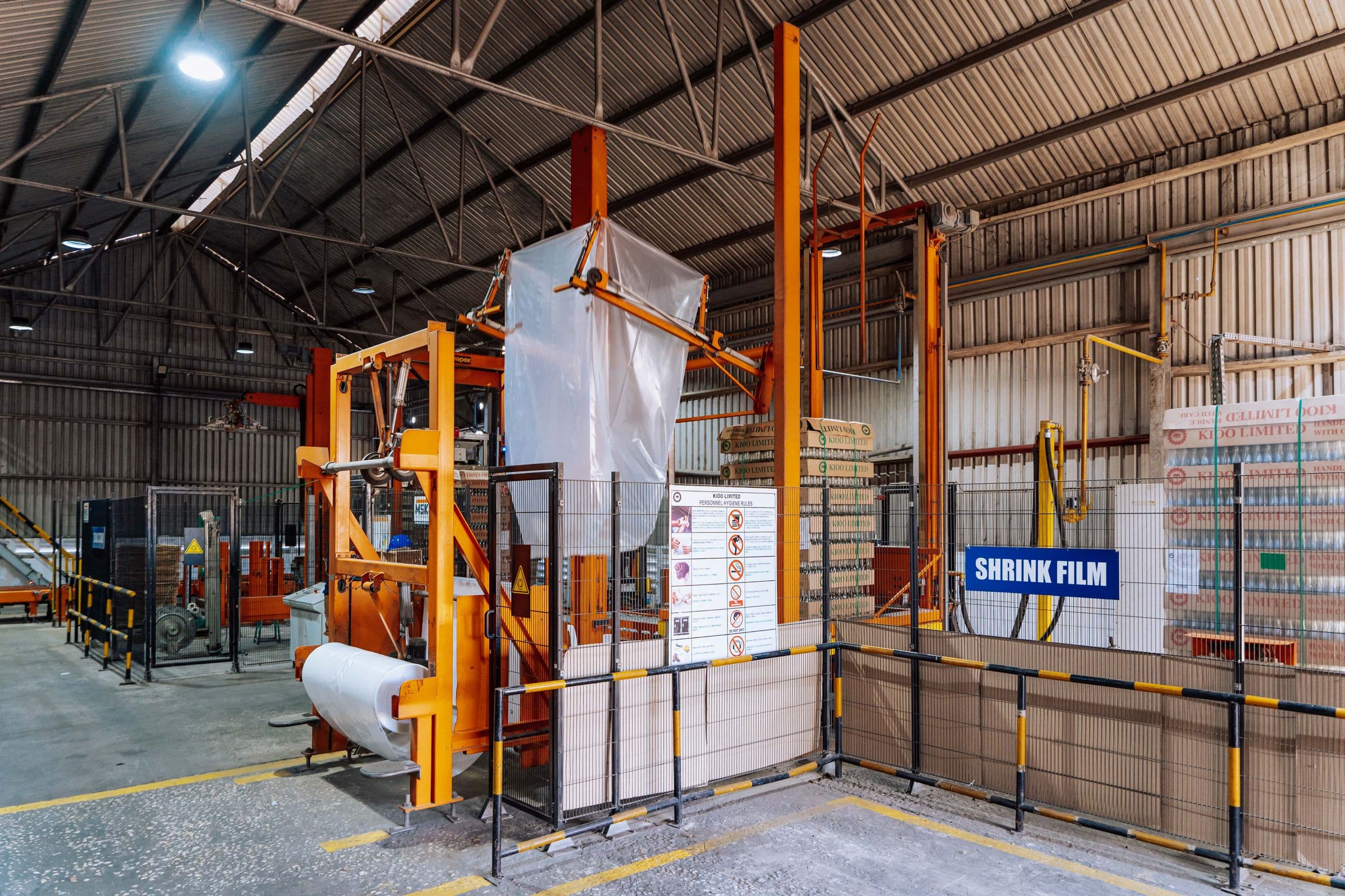 A wide industrial warehouse interior with automated packaging machinery, representative of the manufacturing environment FIBCs move through