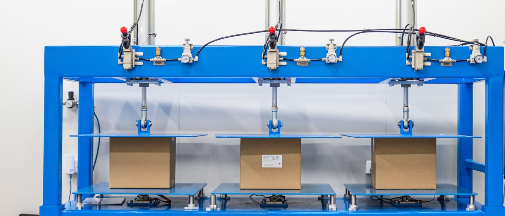 Falcon's blue pneumatic compression tester loading three cardboard cartons at once